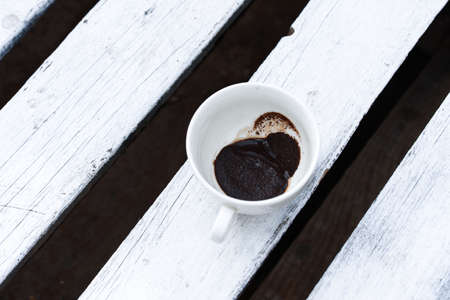 Fragrant coffee in a beautiful cup a cup outside on a wooden table. Spring, breakfast, morning.