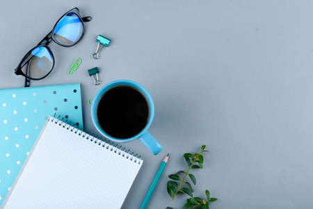 Blue notebook with a blue pencil on a gray background. Phone, glasses and a cup of coffee. Officeの写真素材
