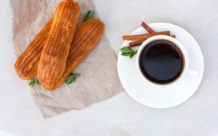 Fragrant coffee with eclairs in the summer cafe.の写真素材