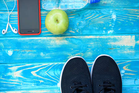 Black sneakers, green apple, drinking water, sports themeの写真素材