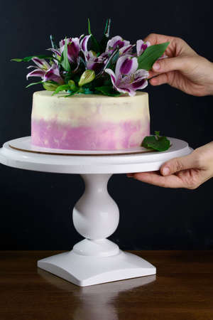 Delicious and beautiful cake with fresh flowers on a stand