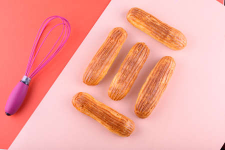 Tasty and beautiful eclairs on a colored background. Delicious dessert. Flat layの写真素材