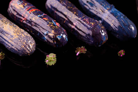 Beautiful and tasty dessert on a slate board with petals. Eclairs with a cup of coffee