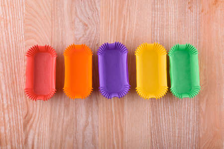 Tasty and beautiful eclairs on a wooden board. Appetizing dessert. Party supplies. flat layの写真素材