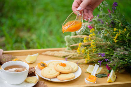 Tasty shortbread, apricot jam, ginger, fragrant tea, lemon, in the summer cottage style with...