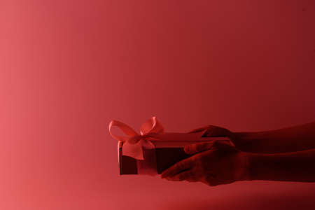 Gift box with pink ribbon in neon light