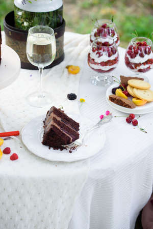 Delicious chocolate cake, red velvet in a glass, wild flowers, berries. Summer picnic outside the city.の写真素材