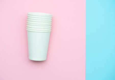 Paper white glasses for drinks and coffee. Glasses on a pink-blue background. Top view, lat lay.