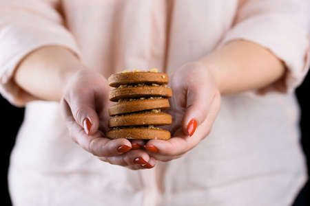 Homemade fragrant gingerbread cookies in female hands with a beautiful manicure. Food photoの写真素材