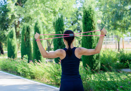 Athletic girl working out in a park. Beautiful embossed back. Health and Sportsの写真素材