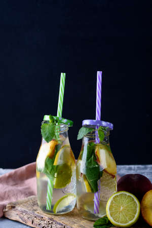 Chilled fruit cocktail on the table. Lemon, lime, peach, mint Summer drinkの写真素材