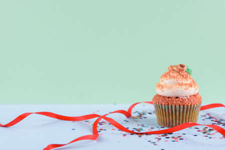 Beautiful festive cupcake on a light green background with sparkles Party