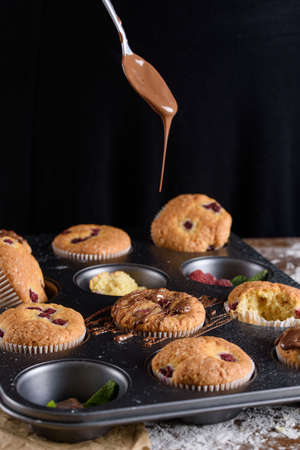 Delicious flavored cupcake with raspberries, white cream, and chocolate icing. Holiday, treats, sweetnessの写真素材