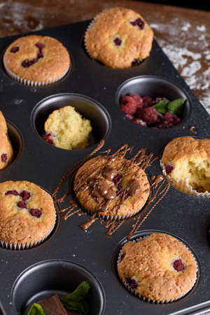 Delicious flavored cupcake with raspberries, white cream, and chocolate icing. Holiday, treats, sweetnessの写真素材