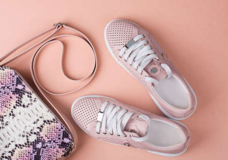 Leather sports shoes with a women s handbag on a light background. Women's accessories