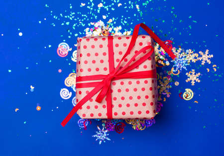 box on a beautiful blue background with a satin ribbon. Holiday concept
