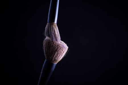 Makeup brush with green powder on the black background. Faceの写真素材