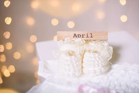 Costume for a newborn girl. Booties, bodik, beautiful bokeh lights. April monthの写真素材