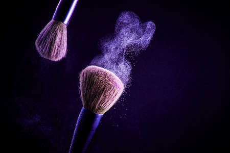 Makeup brush with pink powder on the black backgroundの写真素材