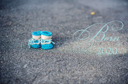 First baby shoes on blue asphalt, handmade. Booties