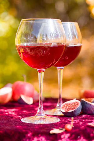Beautiful autumn picnic in nature in the park. Delicious branded cake, figs, red wine, fragrant tea,...