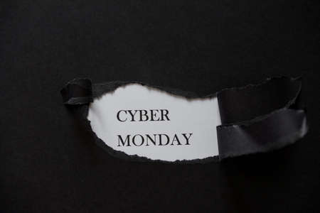 Word Cyber monday printed on a white background with black torn paper. November. Big deal
