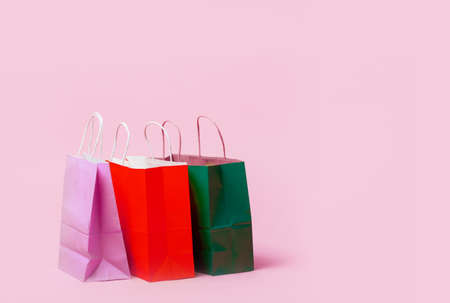 Shopping bags on pink background. Many colorful shopping paper bags standing on pink floor.の写真素材