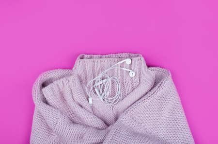 A soft knitted purple sweater with a red notebook on a pink background. Flat layの写真素材
