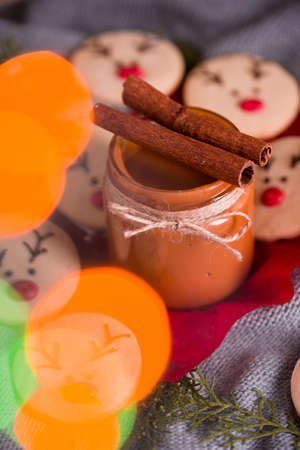 Christmas cookies with homemade salted caramel on a wooden background, neon lights, cinnamon sticks. New years 2020の写真素材
