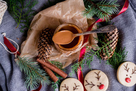 Christmas cookies with homemade salted caramel on a wooden background, neon lights, cinnamon sticks....