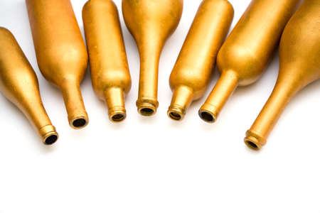 Bottles of different sizes in gold color isolated on a white background. Art decorの写真素材