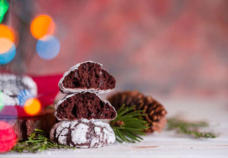 Tasty and fragrant chocolate chip cookies are crushed with powdered sugar, with multi-colored lights on the table. Merry Christmasの写真素材