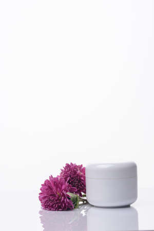 A jar of natural cream on a white background with a flower. Spa cosmeticの写真素材