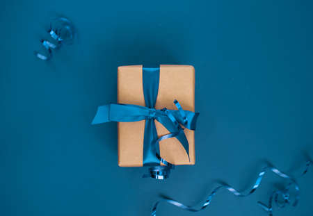 New Year's gift on a blue background, with a beautiful satin ribbon. Christmas. New Year's content. Flat layの写真素材