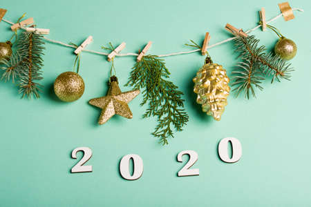 New Year's content 2020 numbers on red strings are half-hung, on a mint background. Zero waste