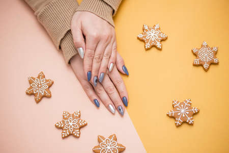 Gift in female hands with a beautiful manicure. Gift in ecological packaging - Furoshiki. Festive background with hearts.の写真素材