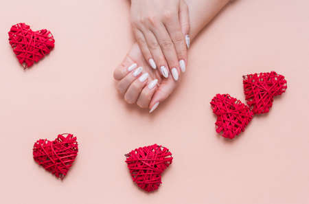 Beautiful stylish female manicure on a pink background with valentinos decor. Happy valentinnos dayの写真素材