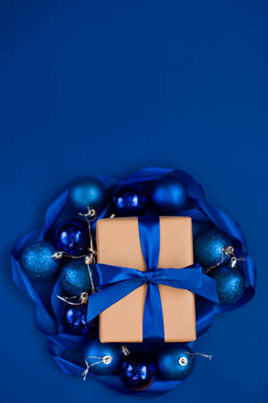 New Year's gift on a blue background, with a beautiful satin ribbon. Christmas. New Year's content. Flat layの写真素材