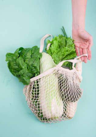 Eco-friendly beige shopping bag with grapes on a white background. String bag with fruits. Zero waste, no plastic concept. Copy spaceの写真素材