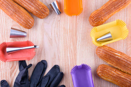 Tasty and beautiful eclairs on a wooden board. Appetizing dessert. Party supplies