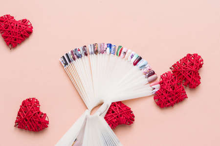 Beautiful stylish female manicure on a gray background with gift in hand. Art contentの写真素材