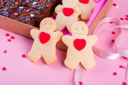 A set of delicious treats in a box with tape. A Valentine's Day gift. Pink background, festive...