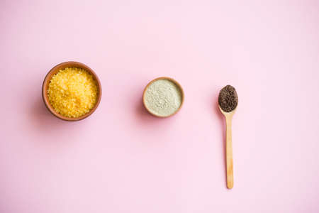 Cosmetic bath salt, grape gomaj for the face, coffee scrub for the body on a pink background. Caring for the face and body.の写真素材