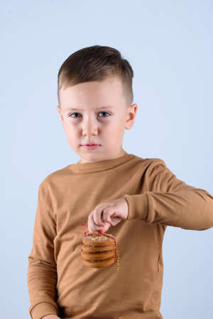 A beautiful little boy, in a brown sweater, holding a glass of milk.の写真素材