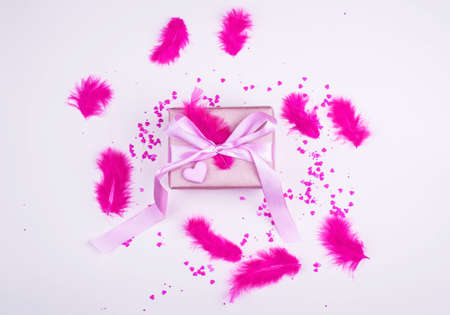 A beautiful festive box with a gift, with bright feathers and hearts. Celebration, decor.の写真素材