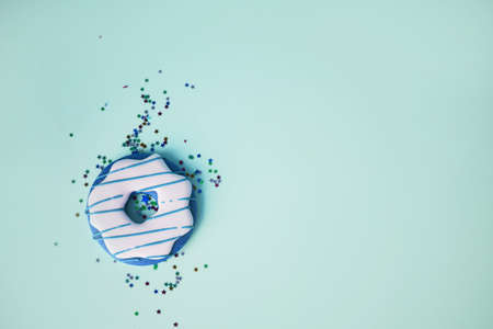 Donuts glazed with sprinkles on a blue background. Sweet desertsの写真素材