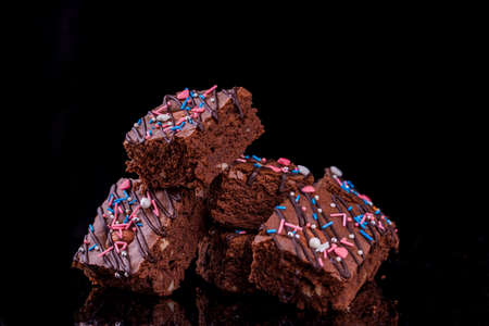 Chocolate brownie dessert with almonds inside, festive powder, on a black background. Sweet food dessertの写真素材