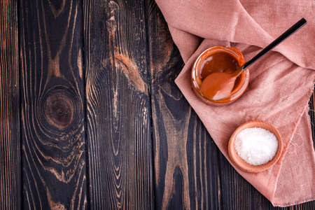 Homemade salted caramel on a dark table with a beautiful black spoon and milk. Delicious dessert for breakfast.の写真素材