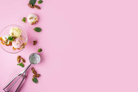 Delicious fragrant ice cream with nuts and mint on a pink background. Copy spaceの写真素材