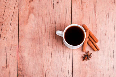 Fragrant natural custard coffee with cinnamon sticks, dried mushrooms, on a wooden background. Copy spaceの写真素材